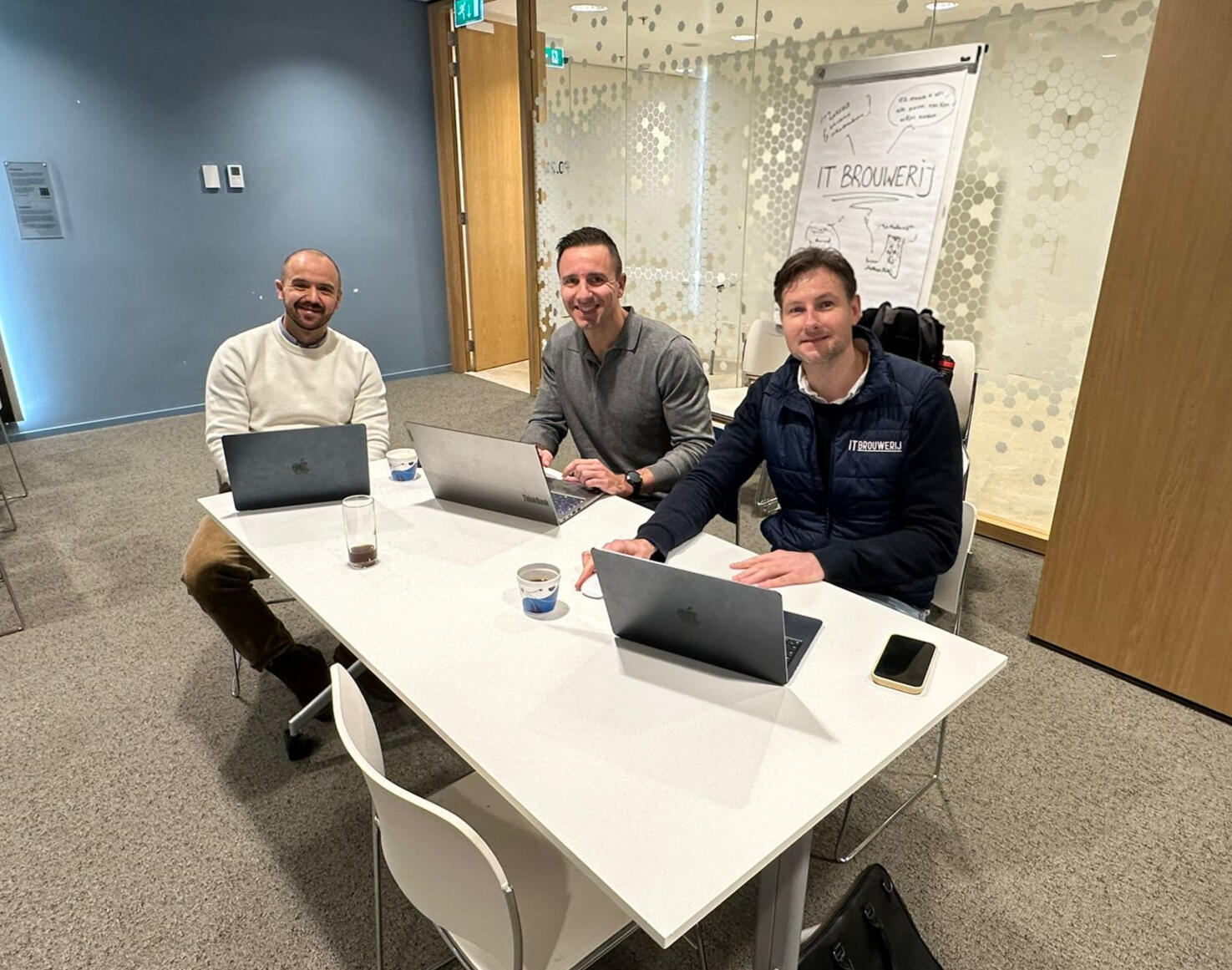 Group of people behind a laptop